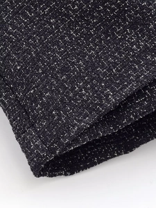 Close-up of black and white tweed fabric texture for luxury women fashion suit