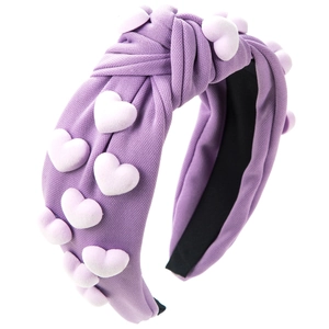 Close-up of a purple knotted headband featuring soft textured fabric and 3D heart details