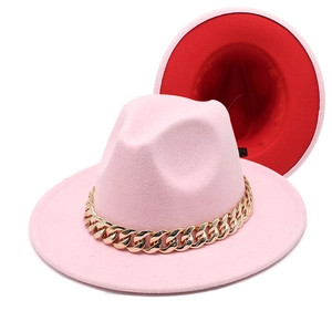 Detail of pink fedora featuring a chunky gold chain and contrasting red inner lining