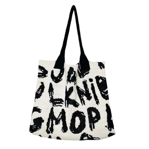Knitted tote bag with black and white letter patterns shown in a centered front view
