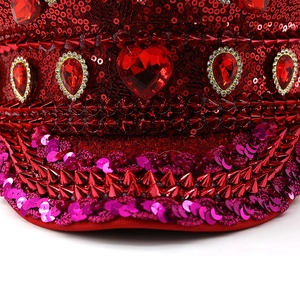 Macro detail of red sequin captain hat with heart ruby gemstone and punk cone spikes