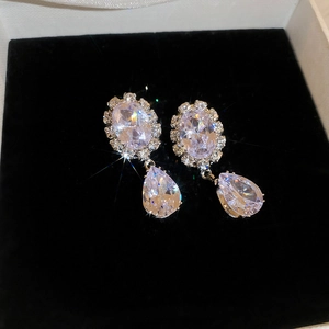 Detail of pear-cut zircon teardrop earrings with silver finish on black velvet display