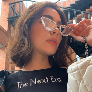 Close-up of cat-eye sunglasses with rhinestone-encrusted metal frames worn by a model