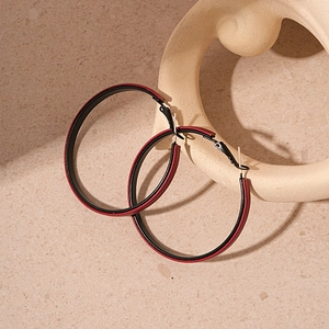 Detail of large circular earrings with vintage red and black faux leather inlays