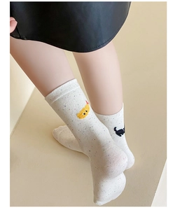Close-up of white cotton socks featuring cute cat and chicken embroidery details