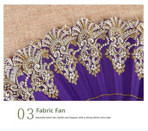 Detail of purple fabric folding fan with gold lace trim on textured linen background
