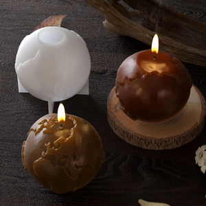Macro detail of 3D earth silicone mold showing textured world map on brown candles