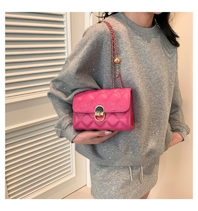 Detail of rose pink quilted crossbody bag with gold chain and metal ball adjustment