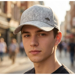Detail of light gray baseball cap with marble texture and metallic mountain badge emblem