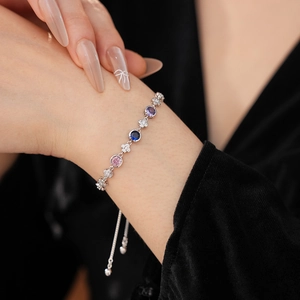Détail d'un bracelet en argent ajustable avec pierres de zircon colorées et motifs trèfle