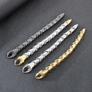 Détail de bracelets tête de mort en noir, or et argent avec fermoirs en forme de griffe