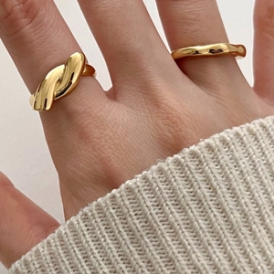 Minimalist gold knot rings set worn with cream sweater for a warm elegant aesthetic