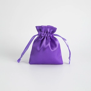 Close-up of a purple satin drawstring gift bag with a glossy finish for jewelry