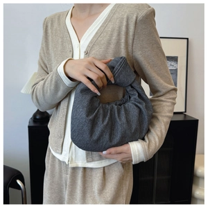 Macro detail of grey textured fabric knot handbag with Japanese-style twisted strap handle