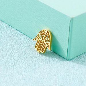 Pendentif main de fatma doré avec motif évidé sur un support géométrique moderne