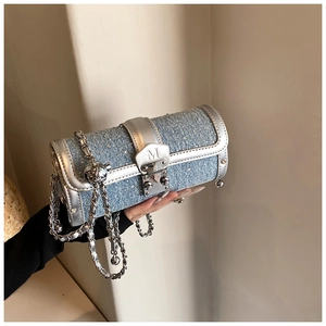 Close-up of blue denim cylinder bag with rhinestones and silver metal chain strap