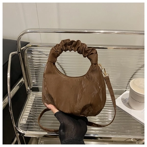 Detailansicht des dunkelbraunen Falten-Griffs und der strukturierten Hobo-Tasche aus Kunstleder