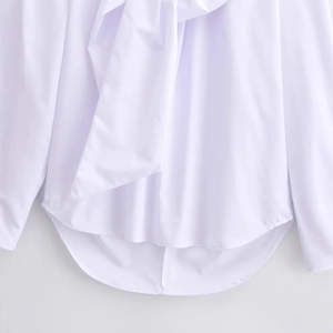 Elegant white long sleeve blouse with curved hem and decorative ribbons detail