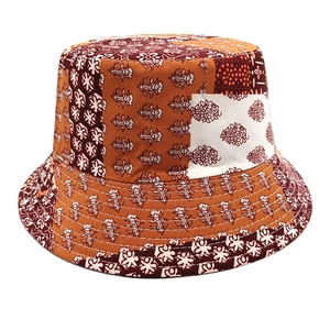 Detail of bohemian patchwork floral prints and quilted stitching on a reversible bucket hat