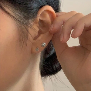 Close-up of a model wearing 925 silver star and smiley face charm earrings set