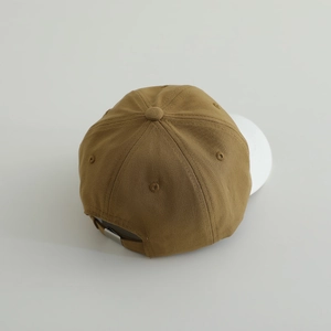 Detail view of brown cotton baseball cap featuring adjustable silver metal buckle at the back