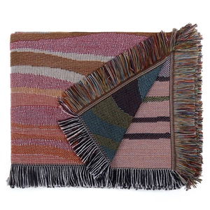 Close-up of bohemian woven blanket with colorful tassels and geometric stripe pattern