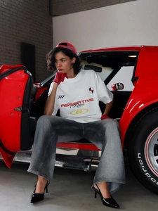 Λεπτομέρεια από λευκό oversized T-shirt με τύπωμα ASSERTIVE Race και street σχέδιο