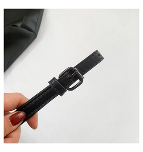 Detail of adjustable black PU leather shoulder strap with dark metal buckle and stitching