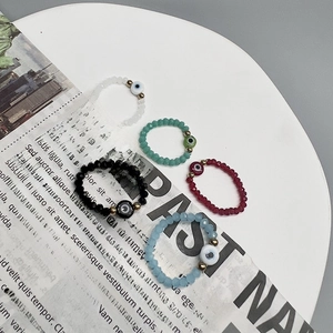 Macro shot of colorful beaded devil's eye elastic rings displayed on vintage paper