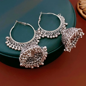 Detail of silver ethnic Jhumka earrings featuring intricate cutout patterns and beadwork
