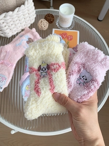 Detail of coral fleece winter socks with cute animal embroidery and pink ribbon bows