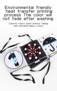 Detail of high contrast black and white baby cloth book with giraffe and umbrella patterns