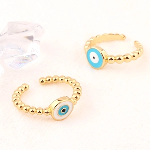 Detail of adjustable golden evil eye rings with enamel finish and beaded band design