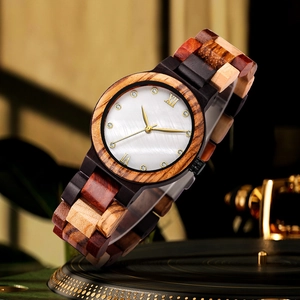 Macro shot of colorful wood watch with pearl dial on a vintage gold record player