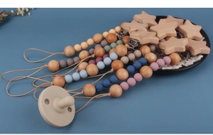 Detail of wooden beech pacifier clips with colorful silicone beads and star clamps