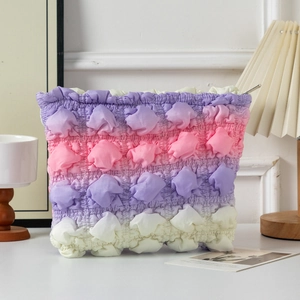 Close-up of cloud makeup bag featuring gradient purple bubble textured fabric detail