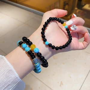 Detail of beaded bracelet set with turquoise, black agate, and gold metal spacers