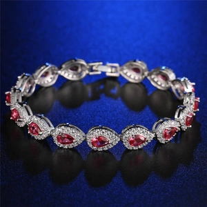 Detailed macro shot of silver chain with teardrop-shaped red stones and halo pavé zircon