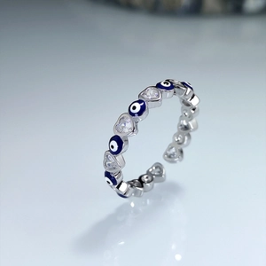 Silver open ring featuring blue evil eye charms and heart-shaped cubic zirconia stones