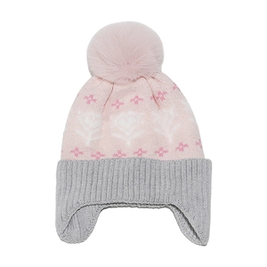 Detail of pink knit winter hat featuring fluffy pompom and intricate floral pattern textures