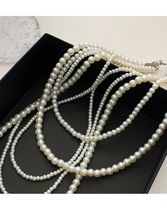 Detailed view of elegant multi-layered white pearl necklace on black display tray