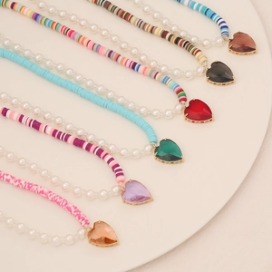 Macro view of six bohemian clay and pearl necklaces with colorful heart pendants