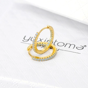 Close-up of gold hoop earrings with pavé set light blue zircons on jewelry card