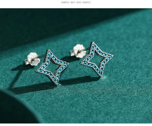 Macro shot of 925 sterling silver star stud earrings with turquoise blue stones