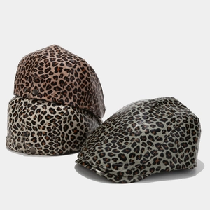 Detail of leopard print PU leather beret hats showing texture and side metal buckle