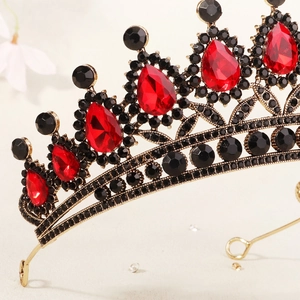 Close-up of luxury Baroque crown with red teardrop crystals and black rhinestones on gold metal