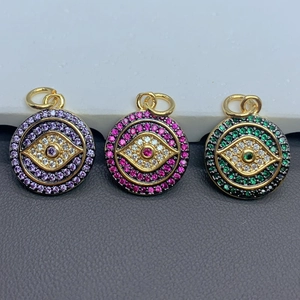 Detailed close-up of zircon Evil Eye round pendants in purple, pink, and green gold plating