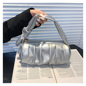 Detail of silver ruched cloud bag showing metallic texture and knotted handle design
