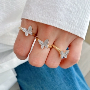 Adjustable gold ring with crystal butterfly worn by a model for a stylish casual look