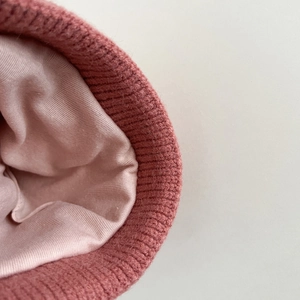Pink knit baby hat with warm thermal lining and ribbed texture for winter comfort